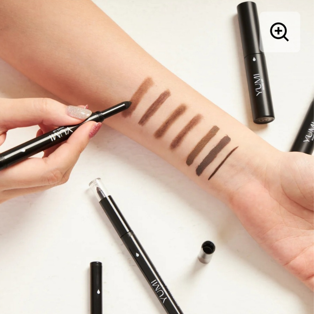 Makeup swatches on a person's arm with various eyeliners from the same brand.